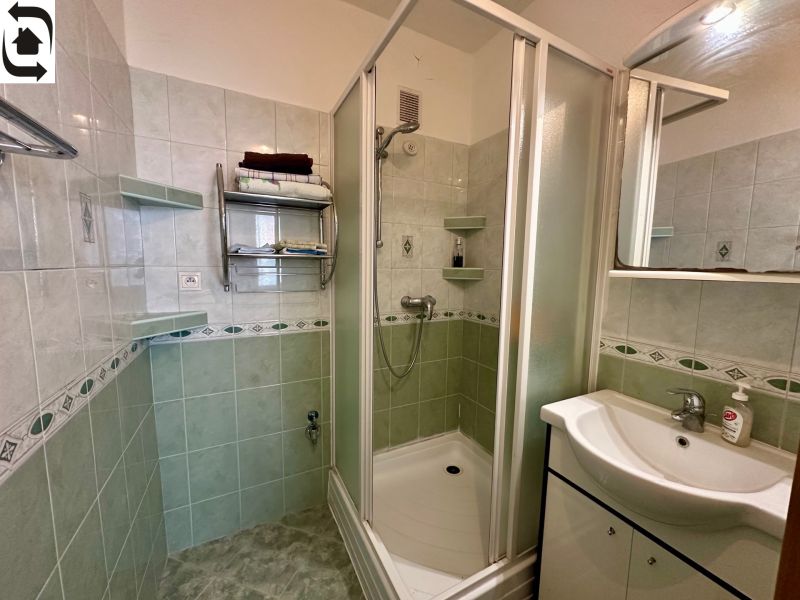 A bathroom with a shower and a sink in a 4-room apartment.