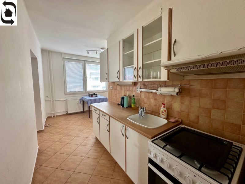 A kitchen in a 4-room apartment with tiles and a worktop.
