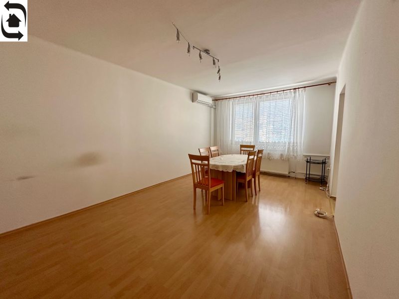 Dining room in a 4-room apartment with a wooden decor floor and a table with chairs.