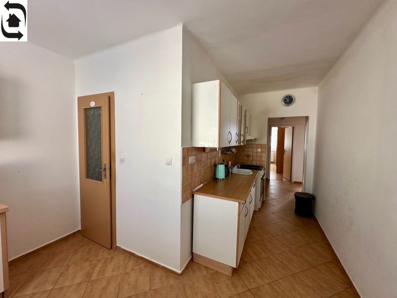 A kitchen in a 4-room apartment with a wooden decor floor and ceramic tiles.