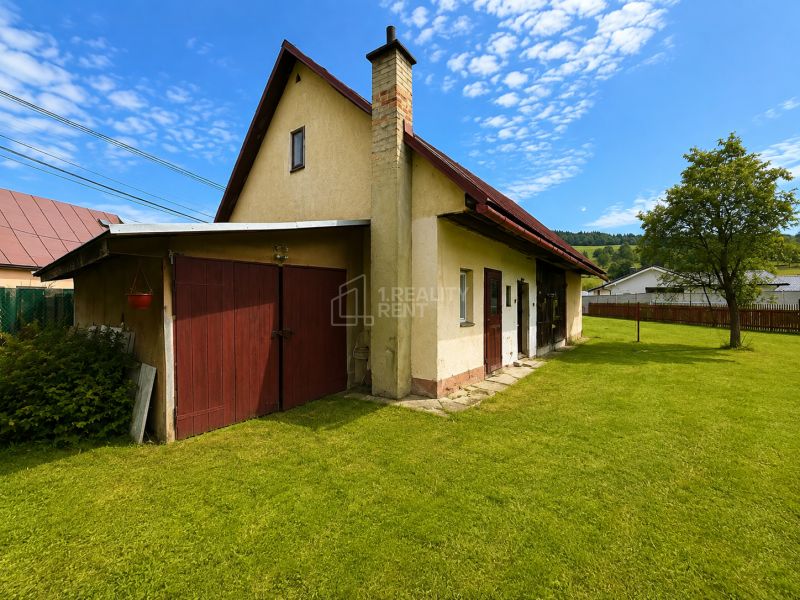 A family house in Oščadnica has a gable roof, a lawn, and an extension on the street in Oščadnica.