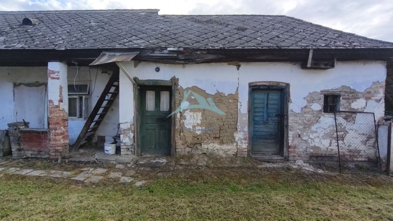 A family house in Opatovská Nová Ves with peeling walls and stairs to the attic.