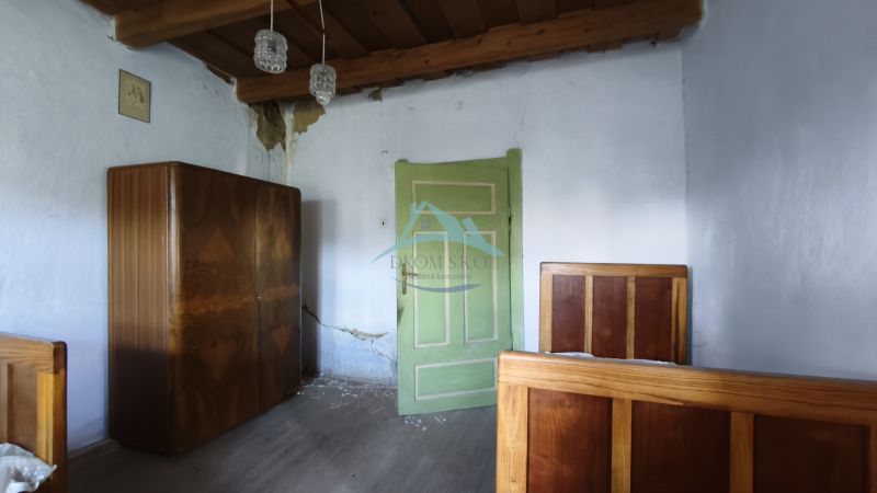 A room in a family house with a wooden ceiling and green doors.