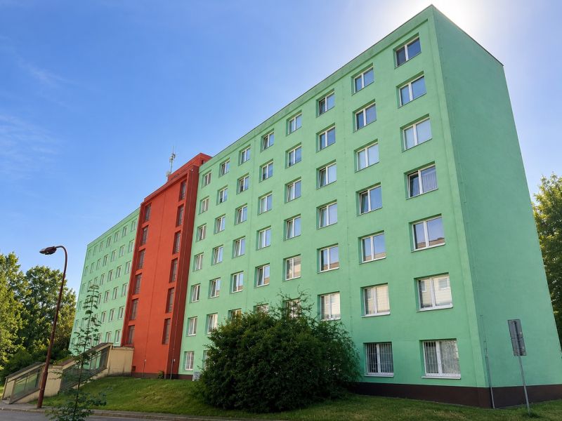 A colorful apartment building on Školská Street in Banská Bystrica with a blue sky.