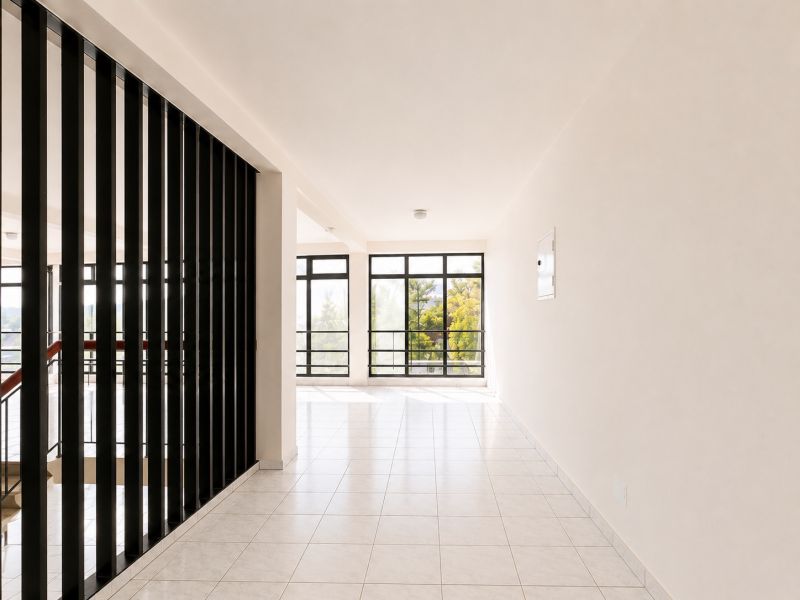 A bright room with large windows and black vertical bars.