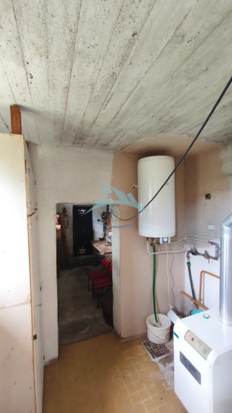 Bathroom in a family house with a boiler and a boiler room, tiled floor.
