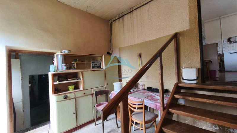 Staircase and older furniture in a family house with wooden decor on the floor.