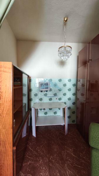 A room with a mirror, a cabinet, and patterned tiles in a family house.