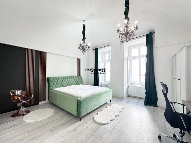 Bedroom in a 3-room apartment with a green bed and chandeliers, floor with wooden decor.