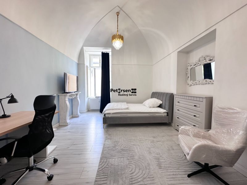 Bright bedroom with a desk, bed, wardrobe, and window, wooden decor flooring.