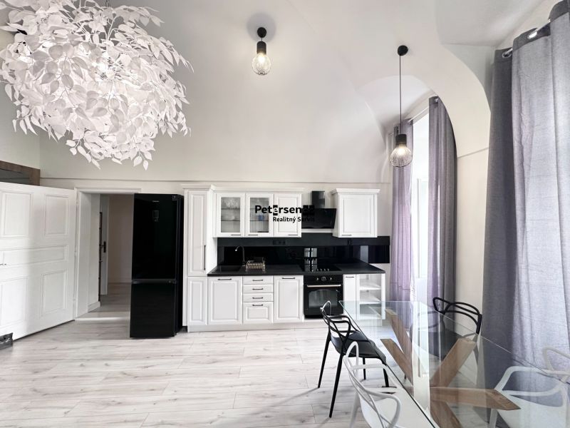 A kitchen in a 3-room apartment with white cabinets, black appliances, and a wood-patterned floor.