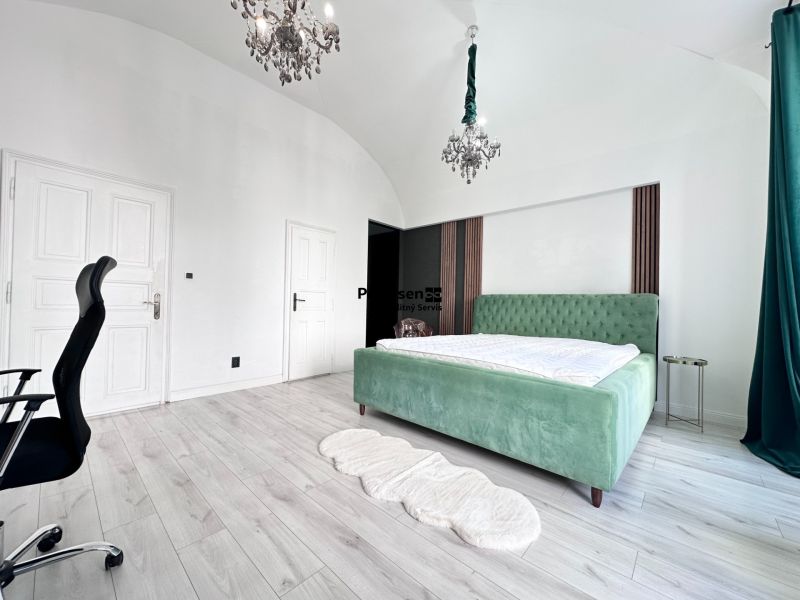 Bedroom in a 3-room apartment with a bed, green curtains, and a wooden decor floor.