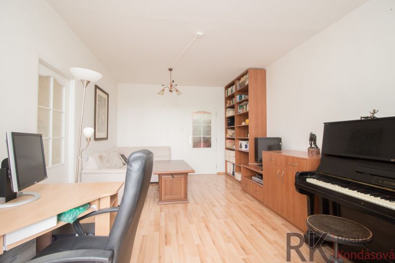 Living room in a 3-room apartment with a piano and a wooden decor floor.