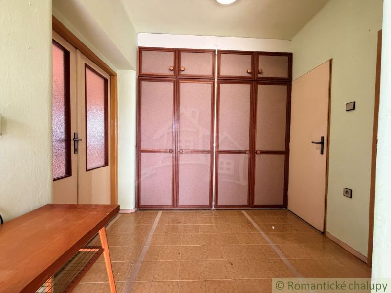 Interior of a family house with a brown cabinet and table, floor with wooden decor.