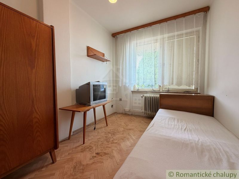 A room in a family house, a floor with a wooden decor, furniture, and a television.