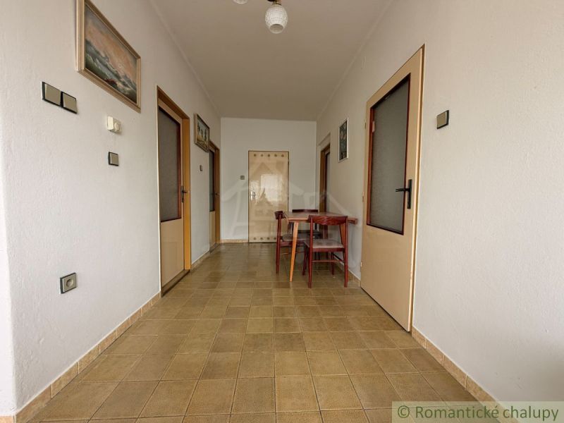 Hallway in a family house with pictures and a kitchen table.