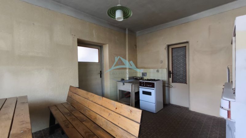 Family house kitchen with a stove and wooden furniture.