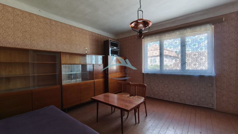 A room in a family house with furniture, armchairs, and a table, with wooden floor decor.