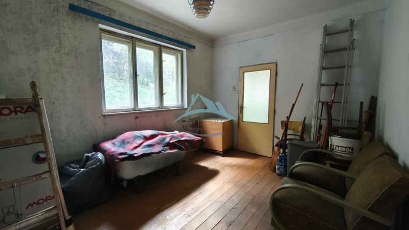 A room in a family house with light, old furniture, and a floor with a wooden decor.