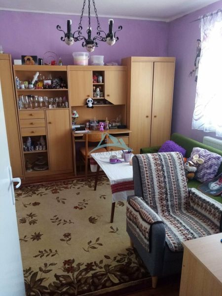 Living room in a family house with purple walls and wooden furniture.