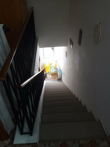 A staircase in a family house with white walls and a railing with a simple design.