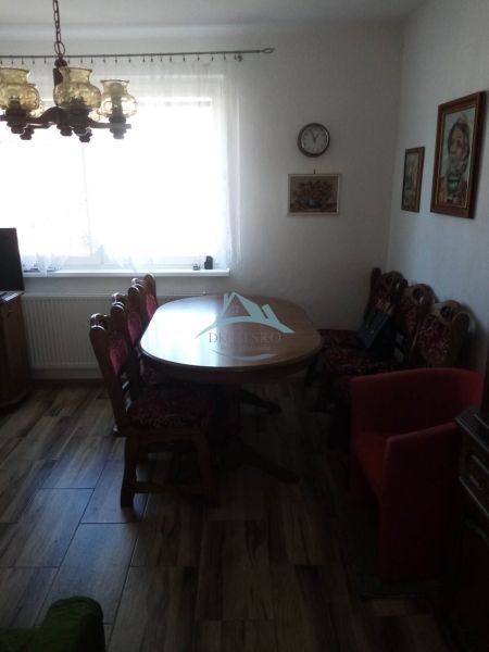 Dining room in a family house with a wooden decor floor, table, and vintage furniture.