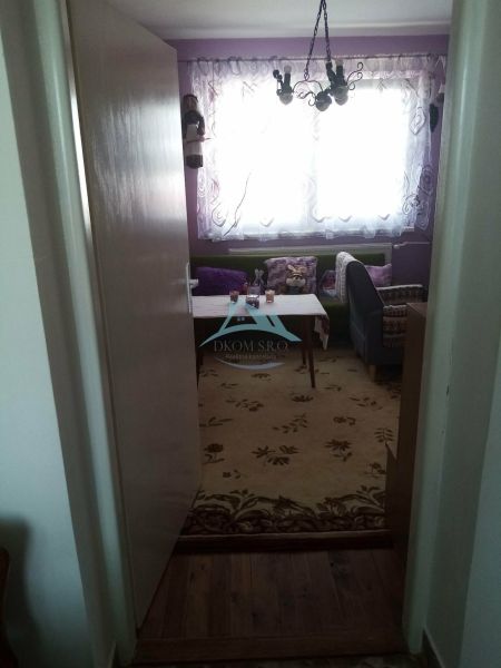 Interior of a family house with a floral carpet and a nicely furnished living area.