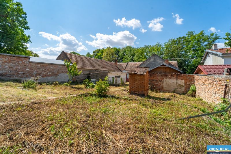 The garden at the family house in Vištuk on Vištuk Street 158, surrounded by a brick wall.