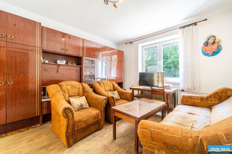 Living room in a family house with furniture and flooring featuring a wood design.