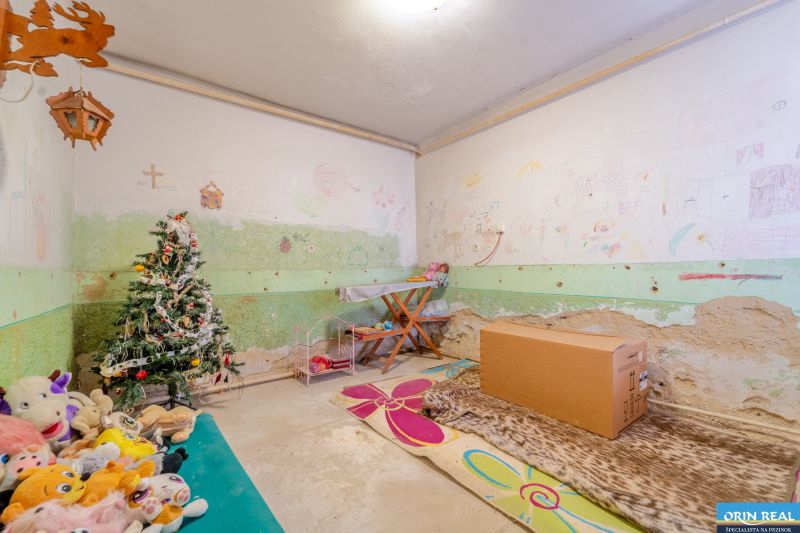 Children's room with a decorated tree, drawings on the walls, and plush toys in a family house.