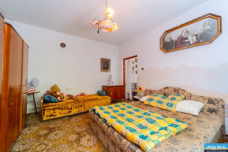 Bedroom in a family house with beds, a wardrobe, carpeted floor, and decorations.