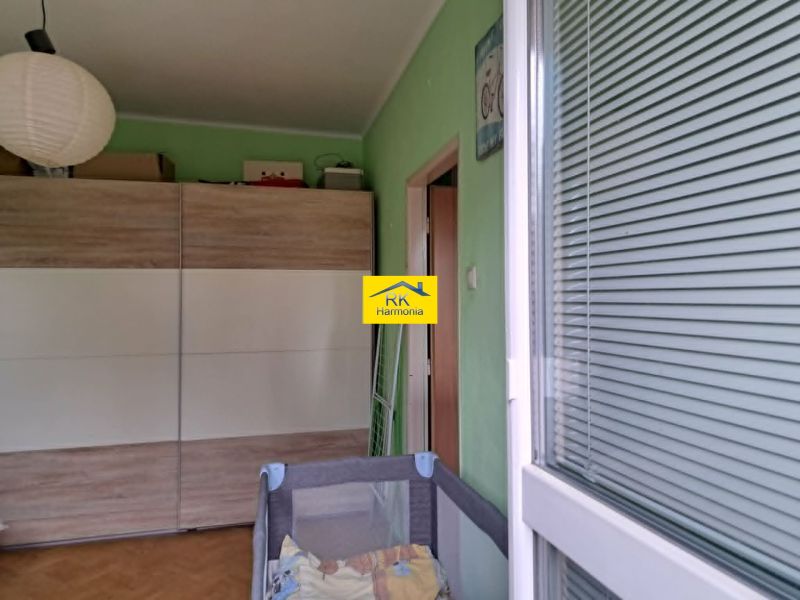 A room in a 2-room apartment with a large wardrobe, wooden decor, and green walls.