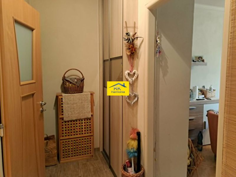 In the 2-room apartment, there is a wooden decor, a basket, decorations, and a view of the kitchen.