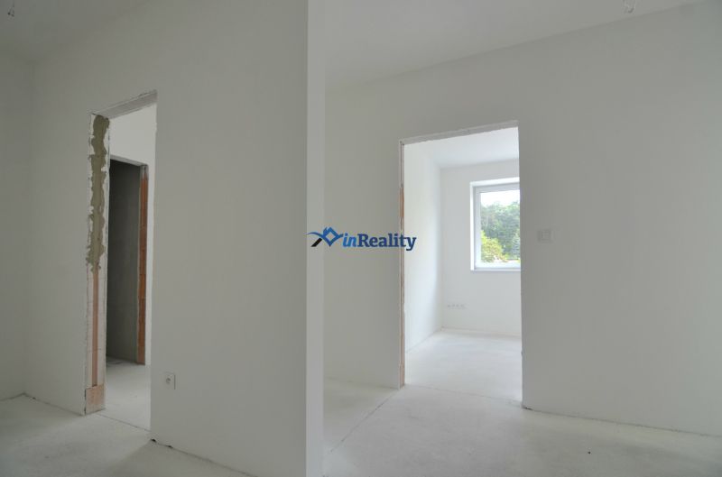 An interior with unfinished door openings and a large window in a 3-room apartment.