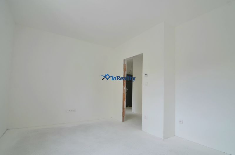 A bright room with white walls and floor in a 3-room apartment.