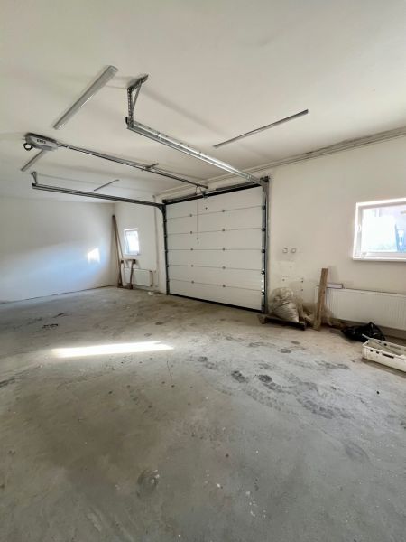 Spacious garage in warehouses and halls with white walls and concrete floor.