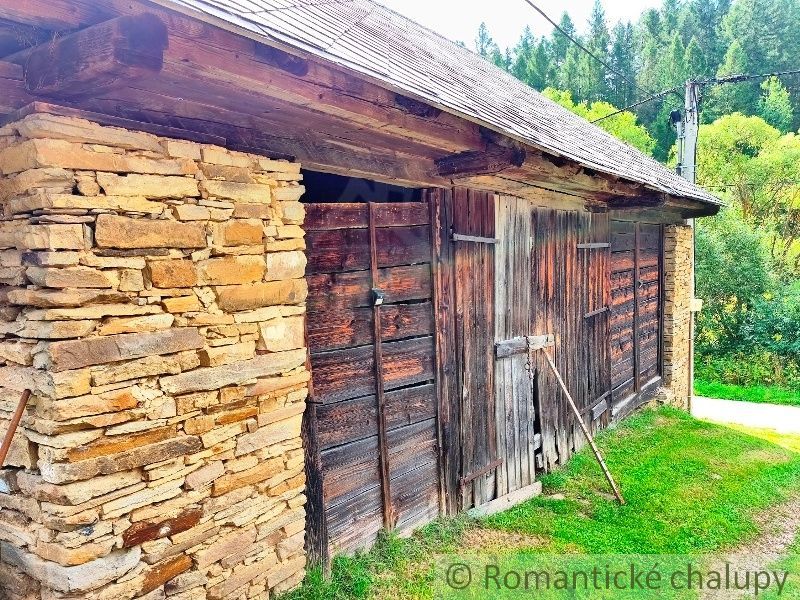 A wooden structure with a stone wall on a plot in Nižné Repaše, suitable for living.