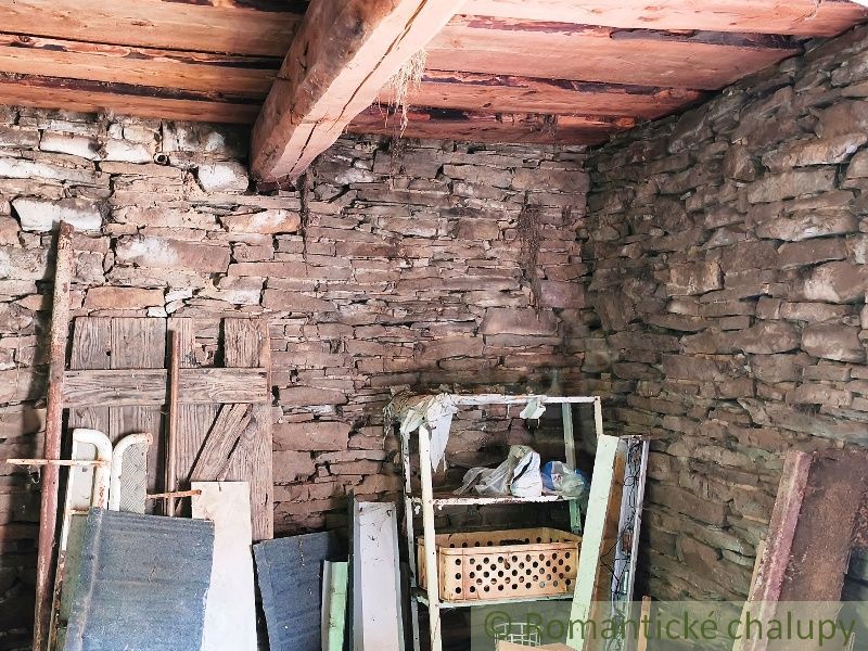 Stone walls and a wooden ceiling in the room on the grounds - living space.