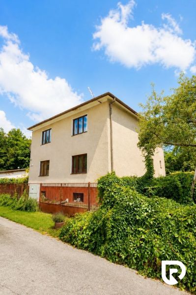 A family house on Pod Laščeky Street in Žilina, surrounded by green vegetation.