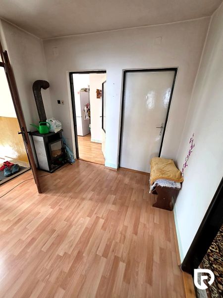 Interior of a family house with a wood-decor floor, a fireplace, and doors to other rooms.