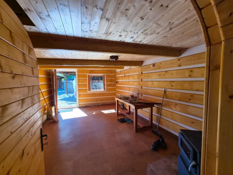 A wooden interior of a family house with a wood-decorated floor and a small window.