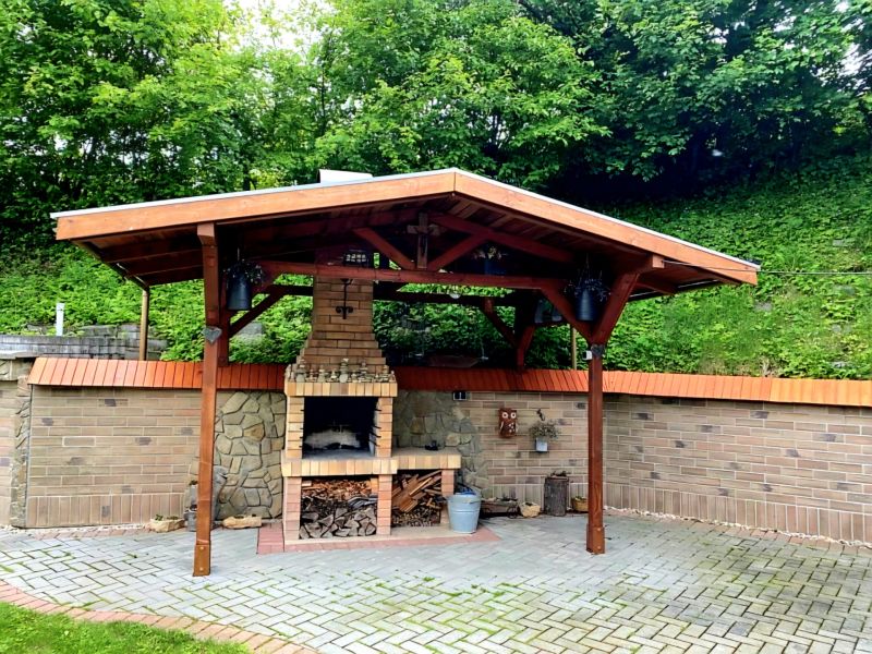 A gazebo with a brick fireplace in the garden of a family house in Mikušovce.
