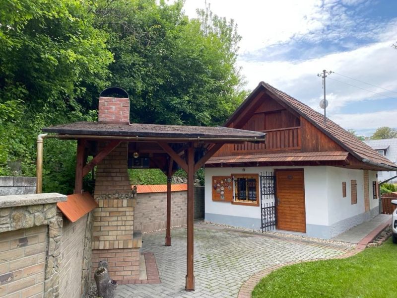 A family house in Mikušovce with a garden shelter and a brick chimney.