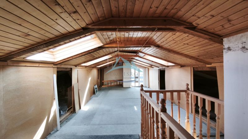 The attic of a family house with wooden paneling and skylights.