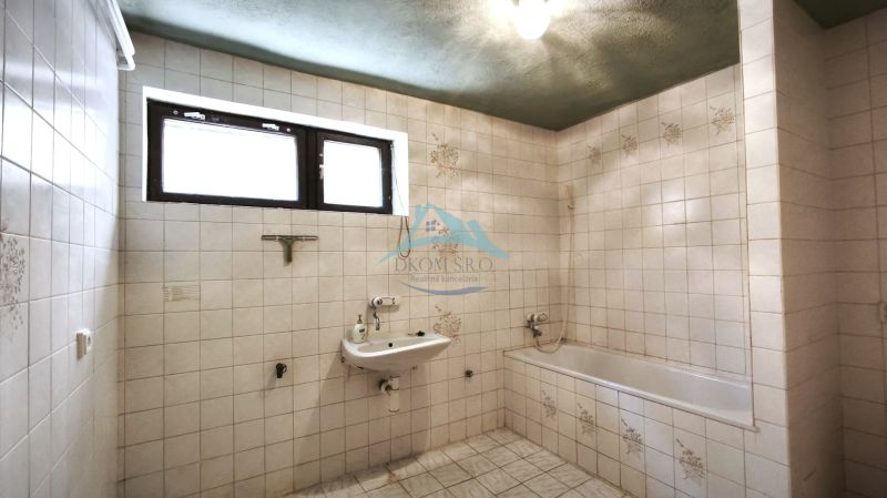 Bathroom with tiles, sink, and bathtub in a family house.