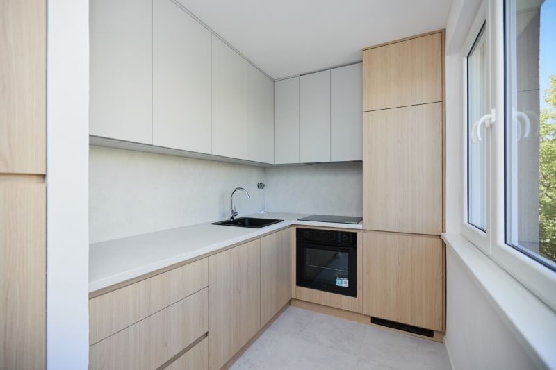 A kitchen unit in a 3-room apartment with wooden elements and light cabinets.