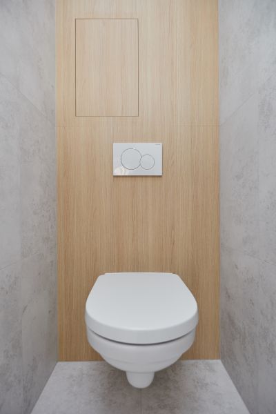 Toilet with a concealed system, floor with wood decor in a 3-room apartment.