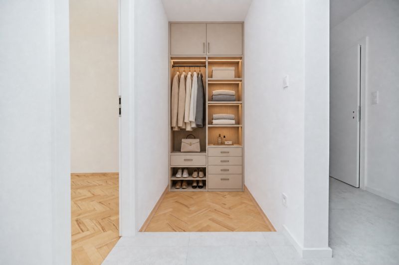 A built-in wardrobe in the hallway of a three-room apartment with a wooden decor floor.
