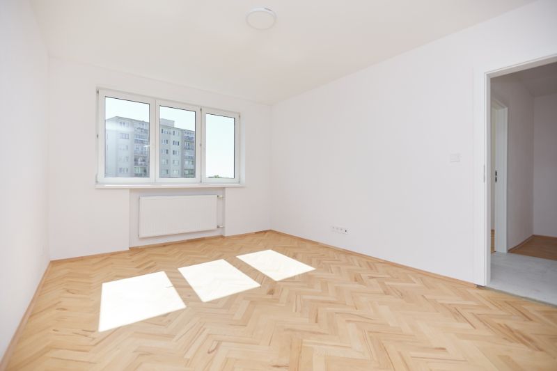 Bright room with wood-patterned flooring in a 3-room apartment.