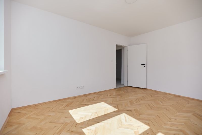 A bright room with white walls and a floor with a wooden decor, a 3-room apartment.